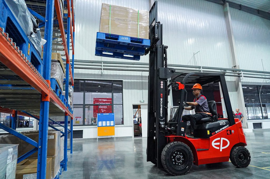 EP Equipment heftruck tilt een pallet naar een hoge magazijnstelling.